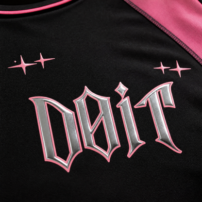 Détail — logo chrome D0iT, couture raglan rose, jersey